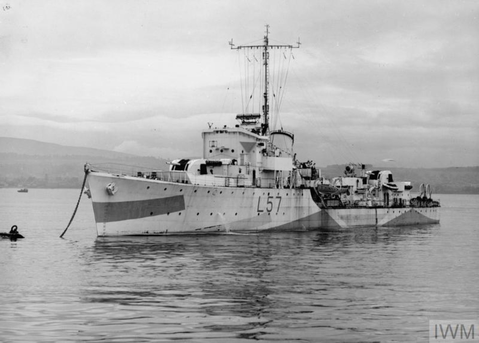 Original black-and-white photograph of HMS Limbourne at anchor, seen from the port bow, with L57 on her hull and the IWM watermark intact.